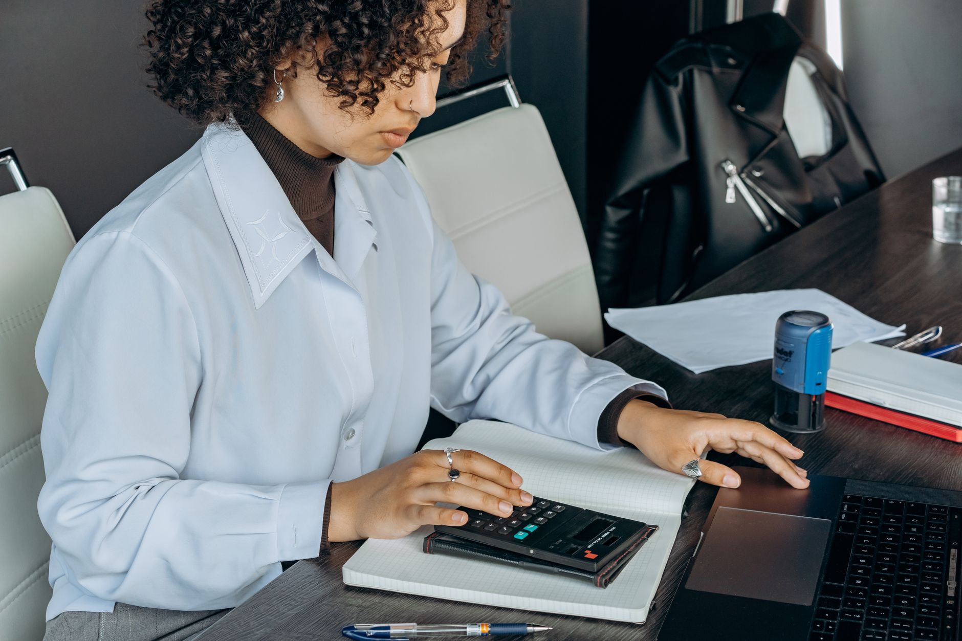 Manual overtime disputes automate math: HR officer calculating overtime pay by hand at an office desk